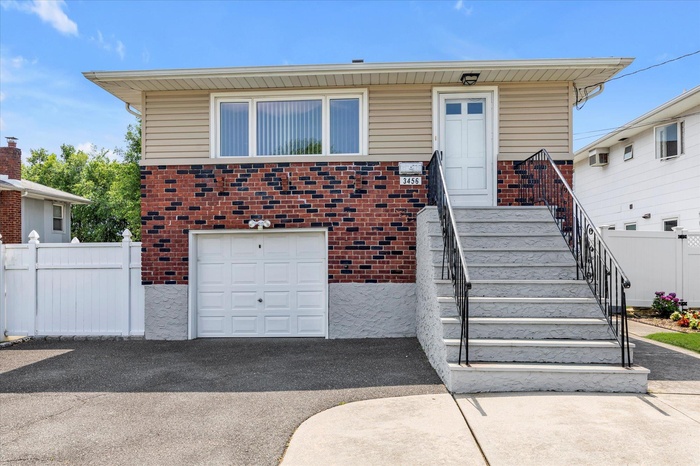 View of front of house with brick siding and an attached garage