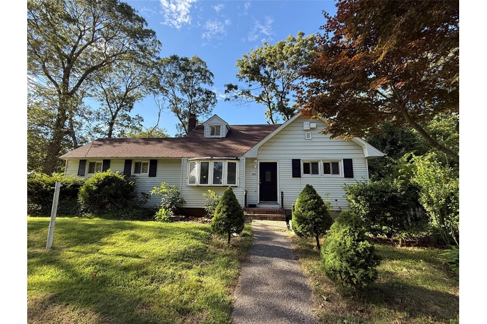 View of front of property featuring a chimney and a front yard