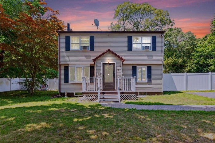 Colonial home with a fenced backyard and a deck