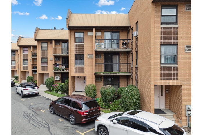 View of apartment building / complex featuring uncovered parking