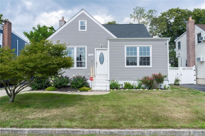 View of front of home featuring entry steps, a gate, roof with shingles, and a chimney