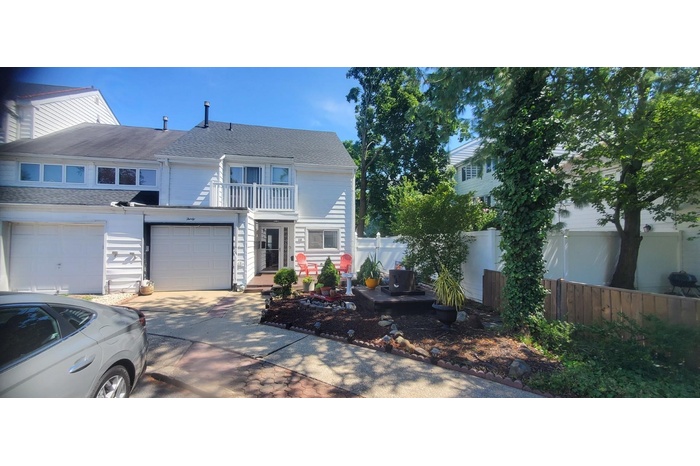 Traditional home with a shingled roof, a balcony, driveway, and an attached garage