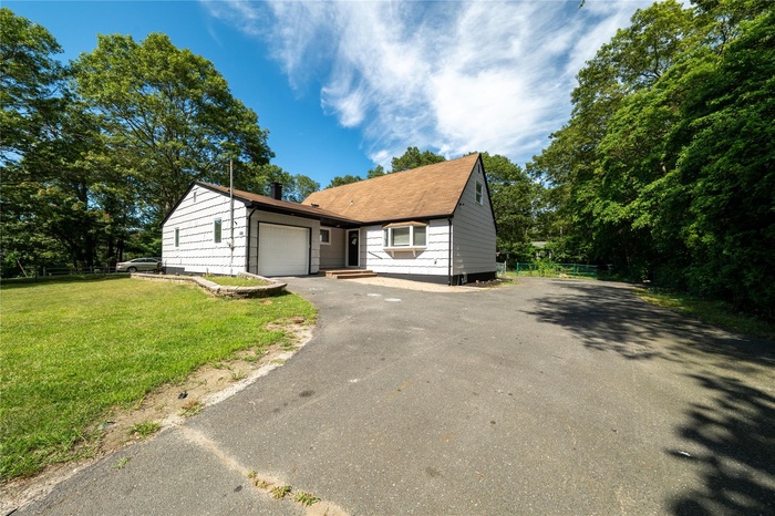 View of front of property with driveway and a garage