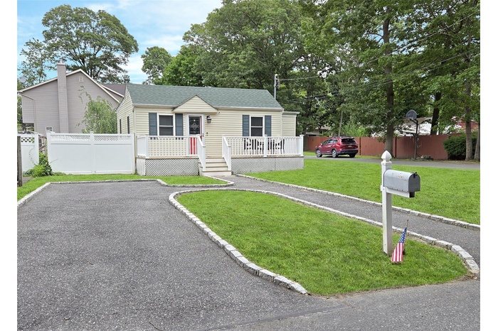 View of front of home with a deck, a shingled roof, and a chimney