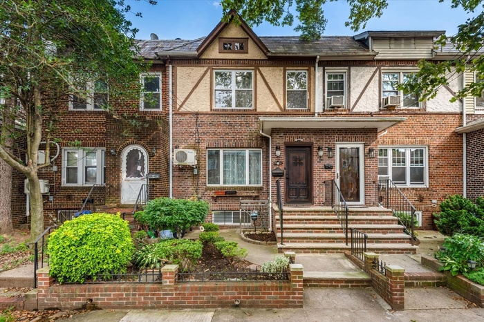 Tudor home featuring brick siding and a high end roof