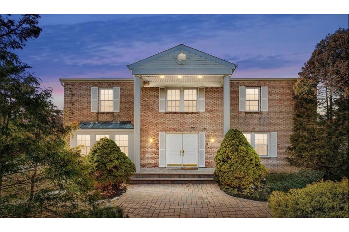 Colonial home featuring brick siding