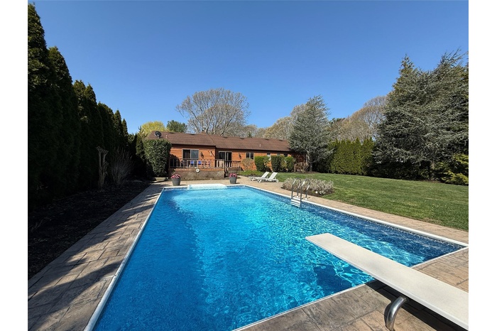 Pool with a diving board and a yard