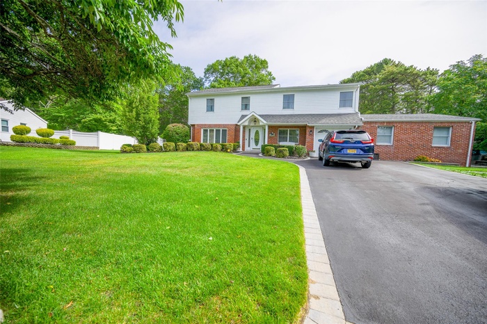 View of front of house with brick siding and driveway