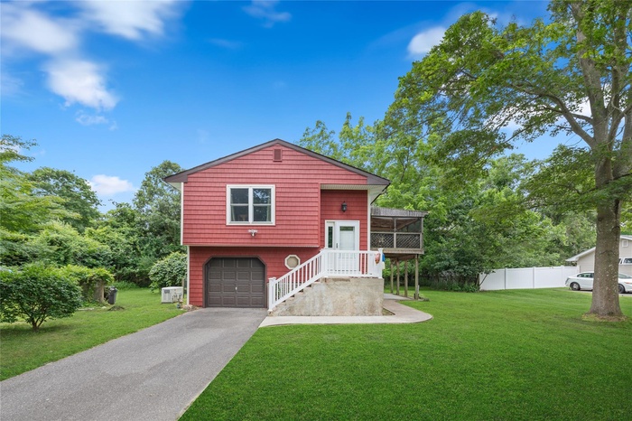 View of front of property featuring asphalt driveway and a garage