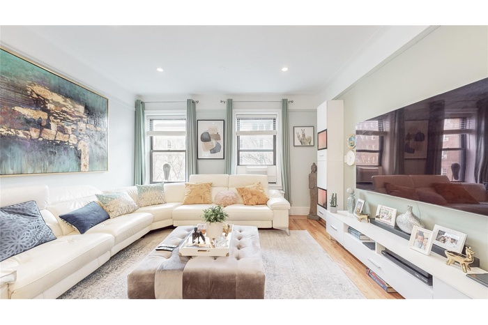 Living room featuring light wood-style flooring, baseboards, and recessed lighting