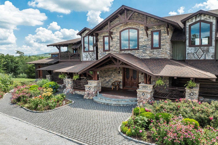 View of front facade with stone siding, and front porch