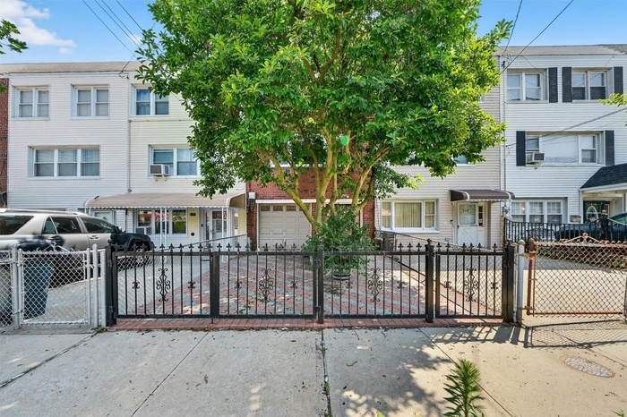 Traditional-style home with a garage, a fenced front yard, a gate, and concrete driveway