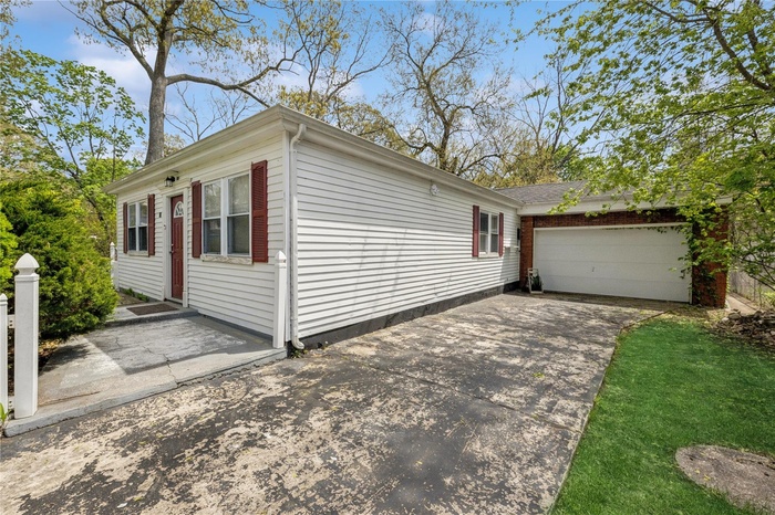 View of side of property with a garage and concrete driveway