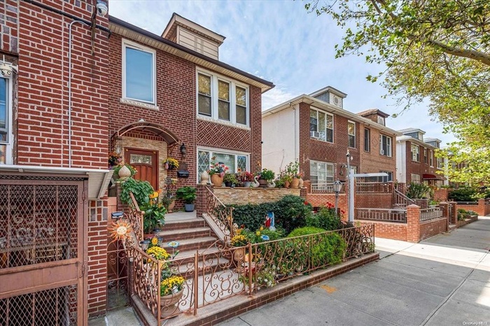 View of front of house with brick siding and fence
