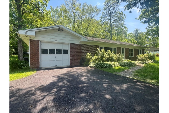 Single story home featuring a garage, brick siding, and asphalt driveway