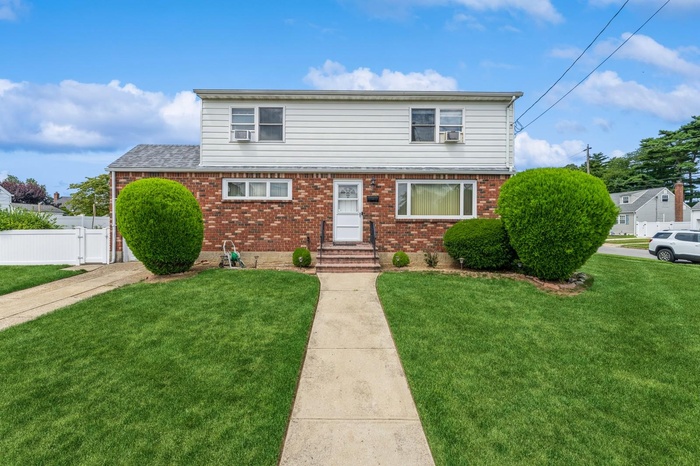 View of front of house with brick siding, entry steps, and a gate