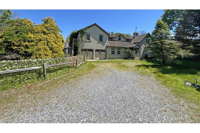 View of front of property with driveway, a garage, stairs, a shingled roof, and board and batten siding