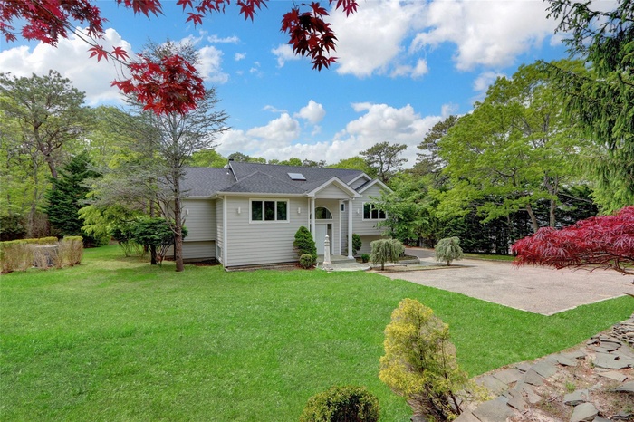 Back of property with a yard and a shingled roof