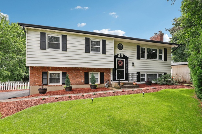 Bi-level home featuring a chimney and brick siding