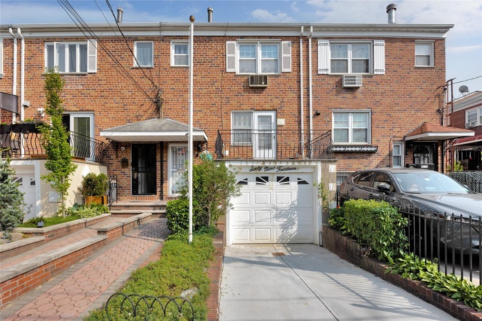 Townhome / multi-family property featuring an attached garage, brick siding, driveway, and cooling unit