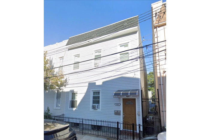 View of front of home featuring a shingled roof, fence, and cooling unit