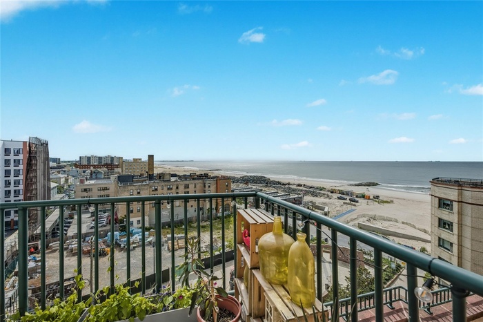 Balcony with a water view and a view of city