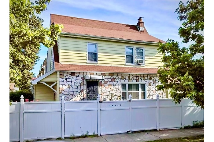 View of front of home with a chimney and stone siding