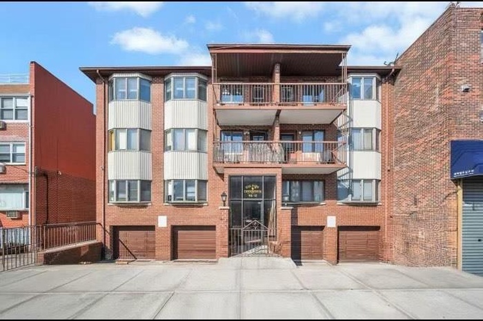 View of apartment building / complex featuring an attached garage and driveway