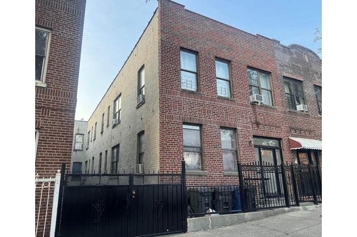 View of building exterior with a fenced front yard and cooling unit