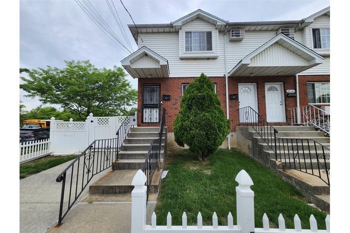 Traditional-style house with a fenced front yard and brick siding