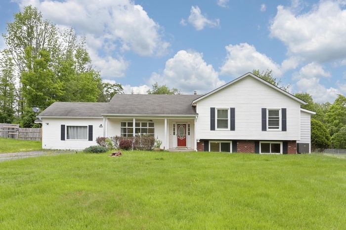 Split level home featuring central air condition unit and covered porch