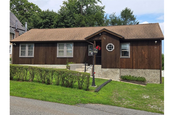 View of front of home with roof with shingles and a front lawn