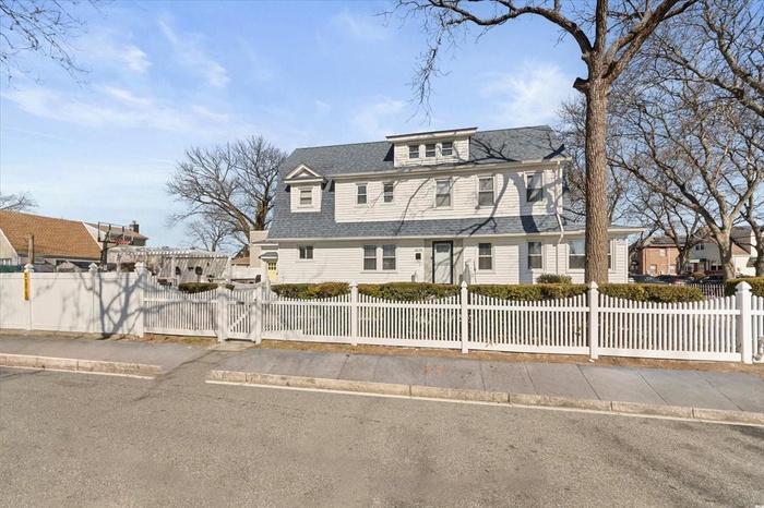 View of front of house with a fenced front yard, a residential view, and roof with shingles