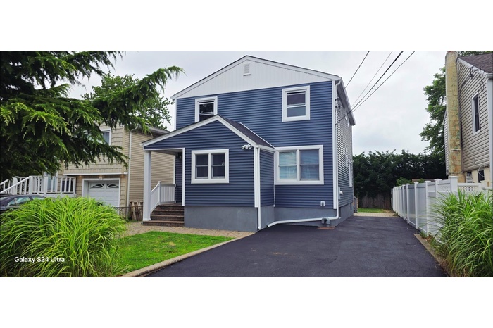 View of front facade featuring a garage and driveway