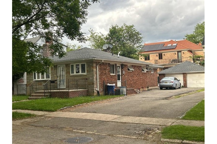 View of front of house featuring a chimney and a garage