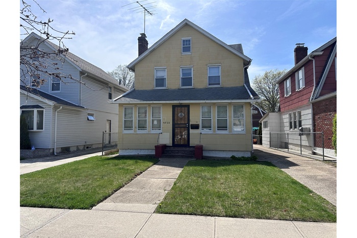 View of front facade featuring a chimney, a shingled roof, fence, and a front yard