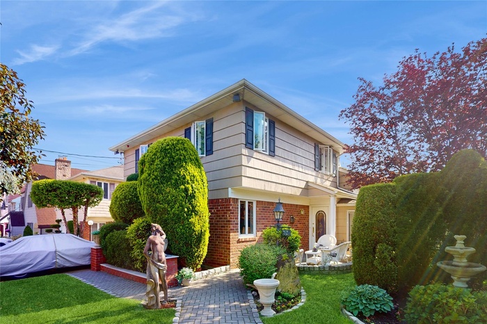 View of front of home with brick siding, a front lawn, and a patio