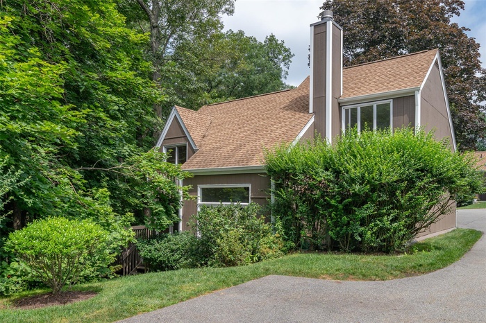 Private, stand-alone townhouse with a spacious wrap-around deck overlooking lush, wooded surroundings.