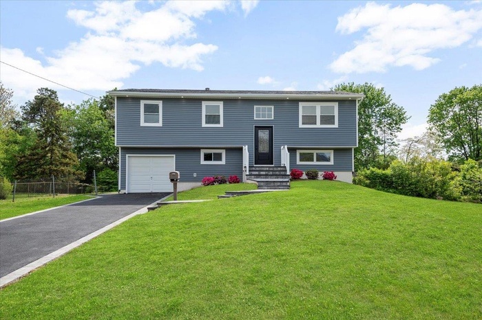 Raised ranch with driveway and an attached garage