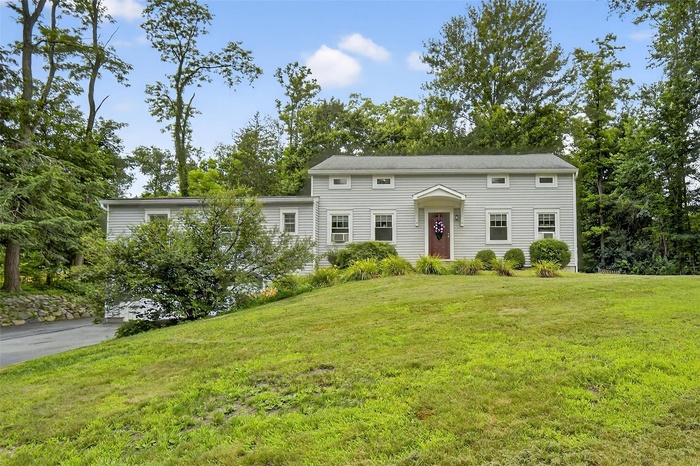 Colonial home featuring a front lawn