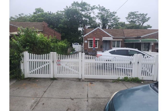 View of front of home featuring brick siding, a gate, and a fenced front yard