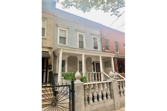 Multi unit property featuring a porch and a fenced front yard