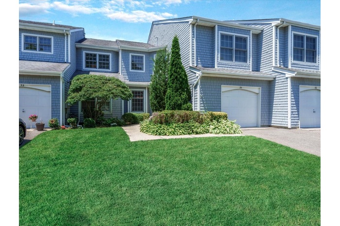 View of front of house featuring a garage, a front lawn, and concrete driveway