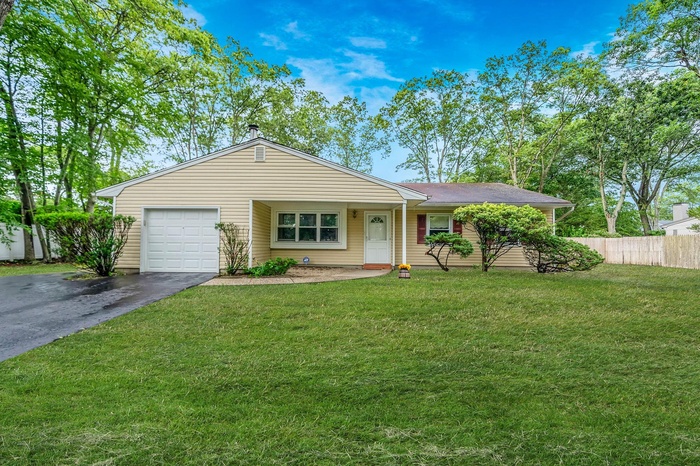 Ranch-style house with a garage and asphalt driveway