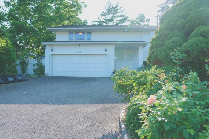 View of front of property with asphalt driveway and a garage