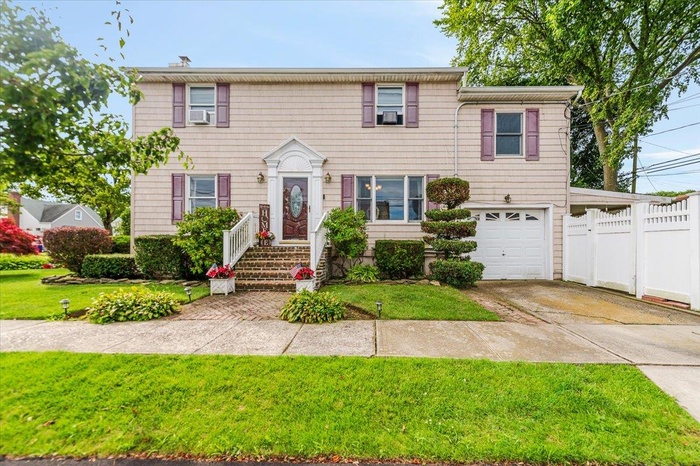 View of front of property featuring concrete driveway and an attached garage