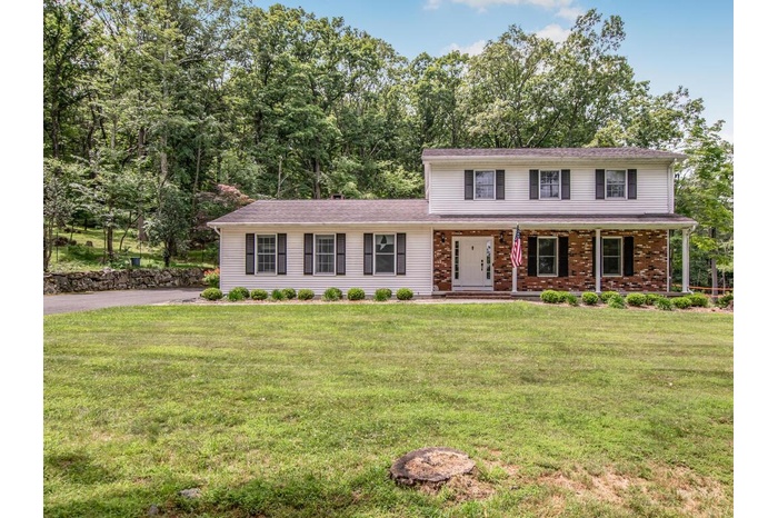 Traditional-style house with a porch and a front lawn