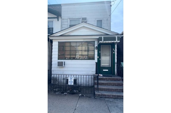 View of front facade featuring a fenced front yard and a wall mounted air conditioner