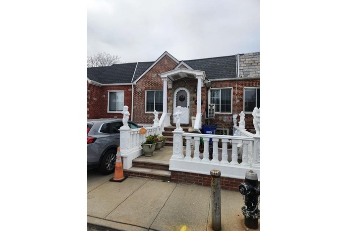 View of front of property with brick siding and roof with shingles