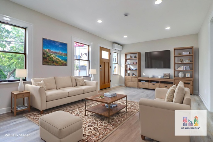 Living room with light wood-type flooring, healthy amount of natural light, recessed lighting, and a wall mounted AC